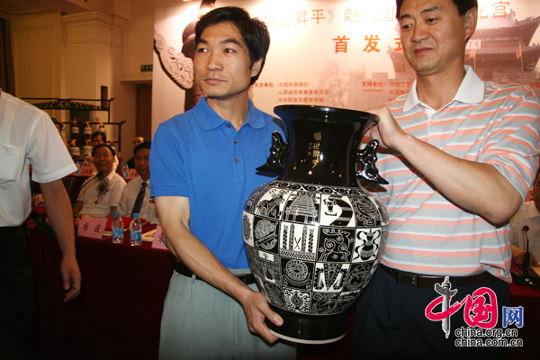 2009年8月8日盛世昇平獻(xiàn)禮國瓷首發(fā)式在北京民族文化宮舉行,圖為盛世昇平刻花瓷交接。 中國網(wǎng) 楊愛博/攝影