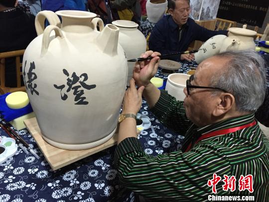 書法名家在陶瓷收藏壺上進行創(chuàng)作。 李俊杰 攝