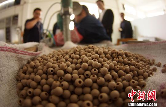 原料中95%的成份為當(dāng)?shù)靥沾蓮U渣,工人將其粉碎后,制作成圓形瓷珠。 王昊陽 攝